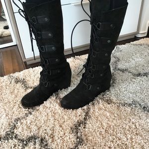 Black Sorel tall lace-up wedge winter boots.